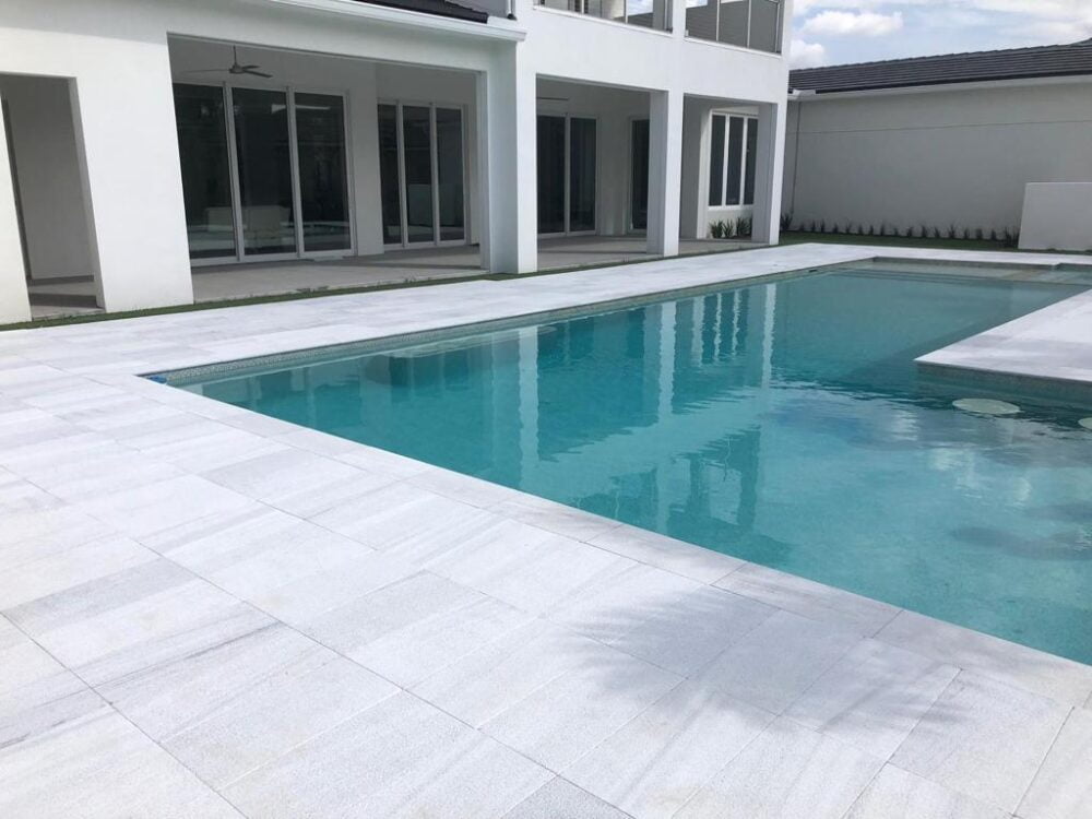 Bianco Marble Pool Coping by Noda Stone in Luxurious Pool Setting