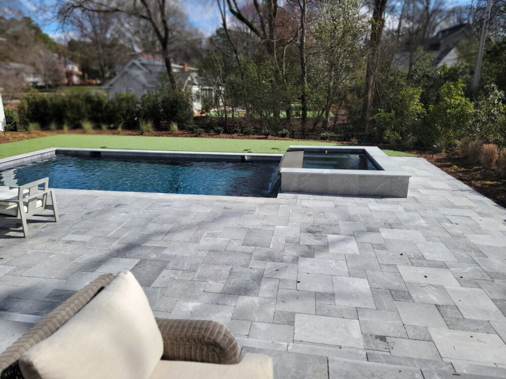 Elegant pool design featuring Savannah Gray pool coping by Noda Stone Inc.